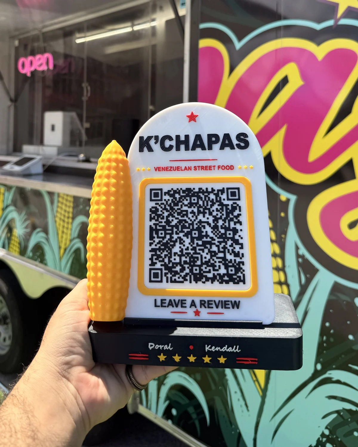 K'Chapas review stand: 3D-printed in the restaurant's colors, with a corn cob and a QR code that opens its Google reviews.